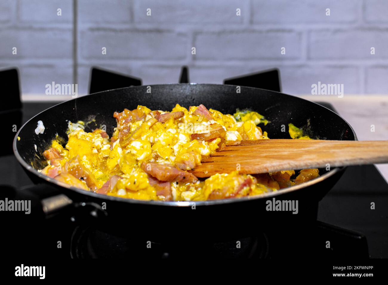 Frying bacon in stainless steel frying pan on stove top Stock Photo - Alamy