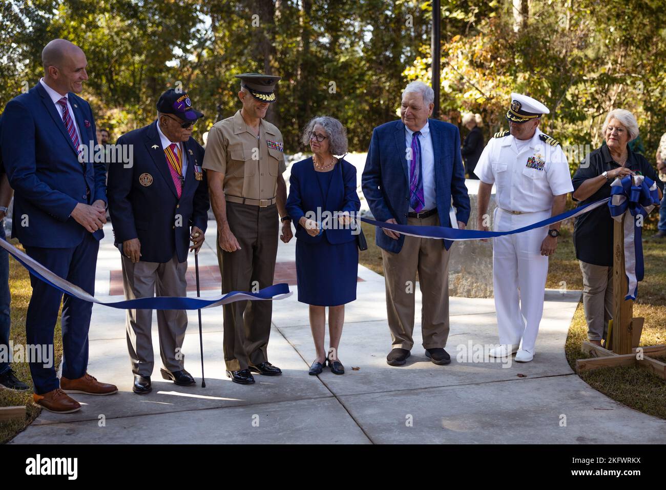 Ms. Abbe Godwin, center, monument artist and sculptor, cuts the ribbon
