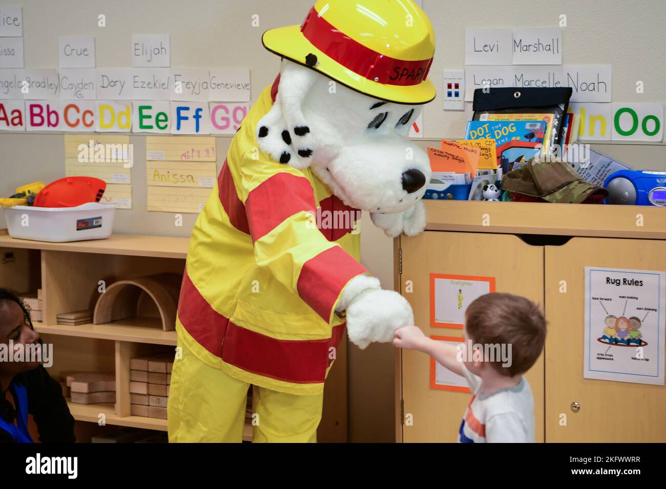 Sparky the Fire Dog greets a child during a story time visit from the