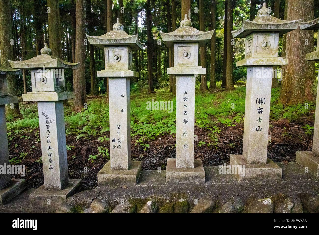 Japanese stone toro lanterns at shrine entrance in the forest Stock Photo