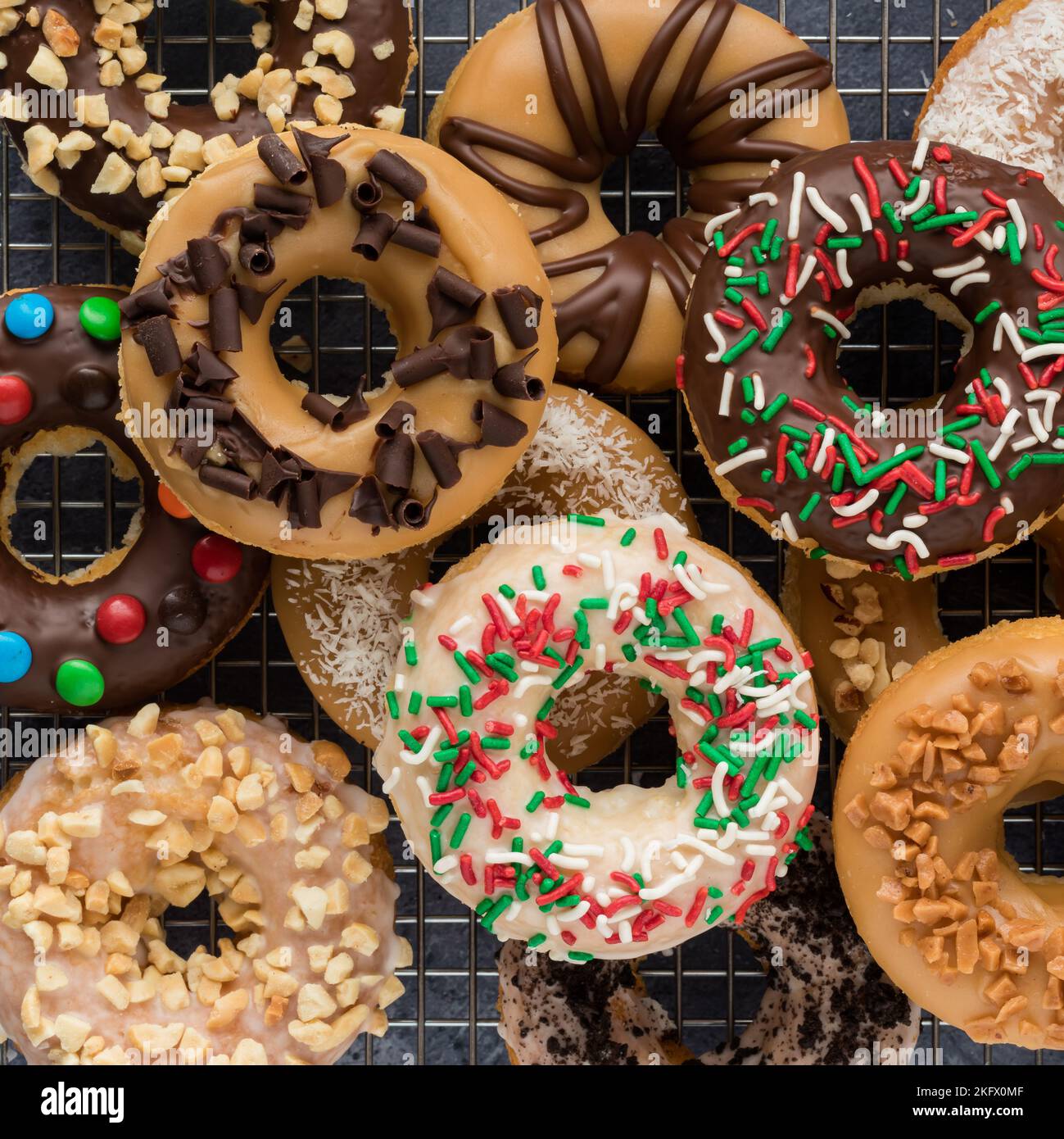 Top down view of a pile of fresh homemade donuts with various toppings. Stock Photo