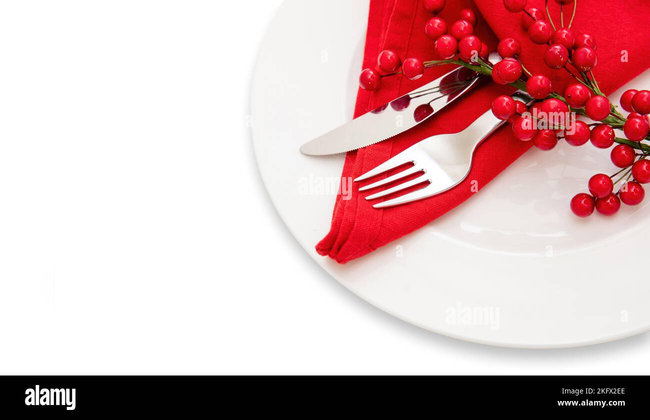 Holiday table setting. Silver Cutlery and red cloth napkin on white plate, close up view. Christmas New Year celebration dinner Stock Photo