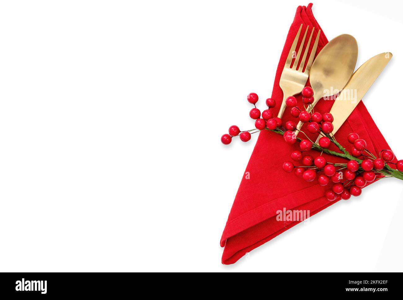 Holiday table setting. Golden Cutlery and red cloth napkin isolated on white, top view. Christmas New Year , celebration dinner Stock Photo