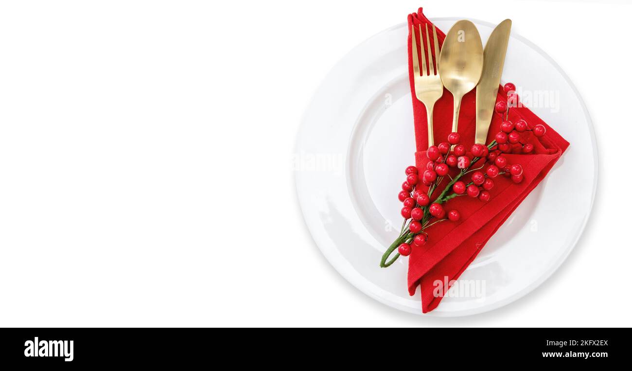 Holiday table setting. Golden Cutlery and red cloth napkin on plates isolated on white, top view. Christmas New Year celebration dinner Stock Photo