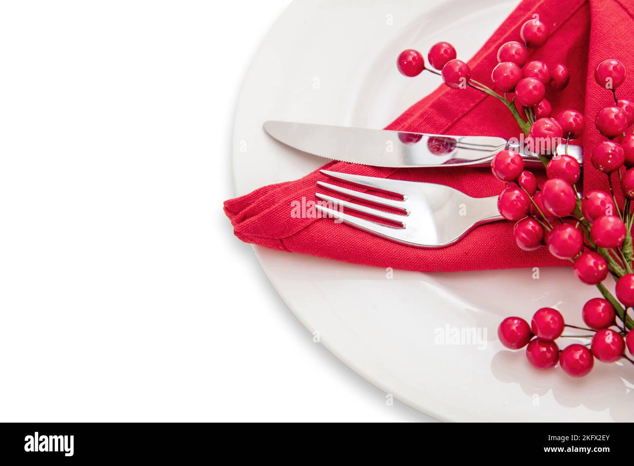 Holiday table setting. Silver Cutlery and red cloth napkin on white plate, close up view. Christmas New Year celebration dinner Stock Photo