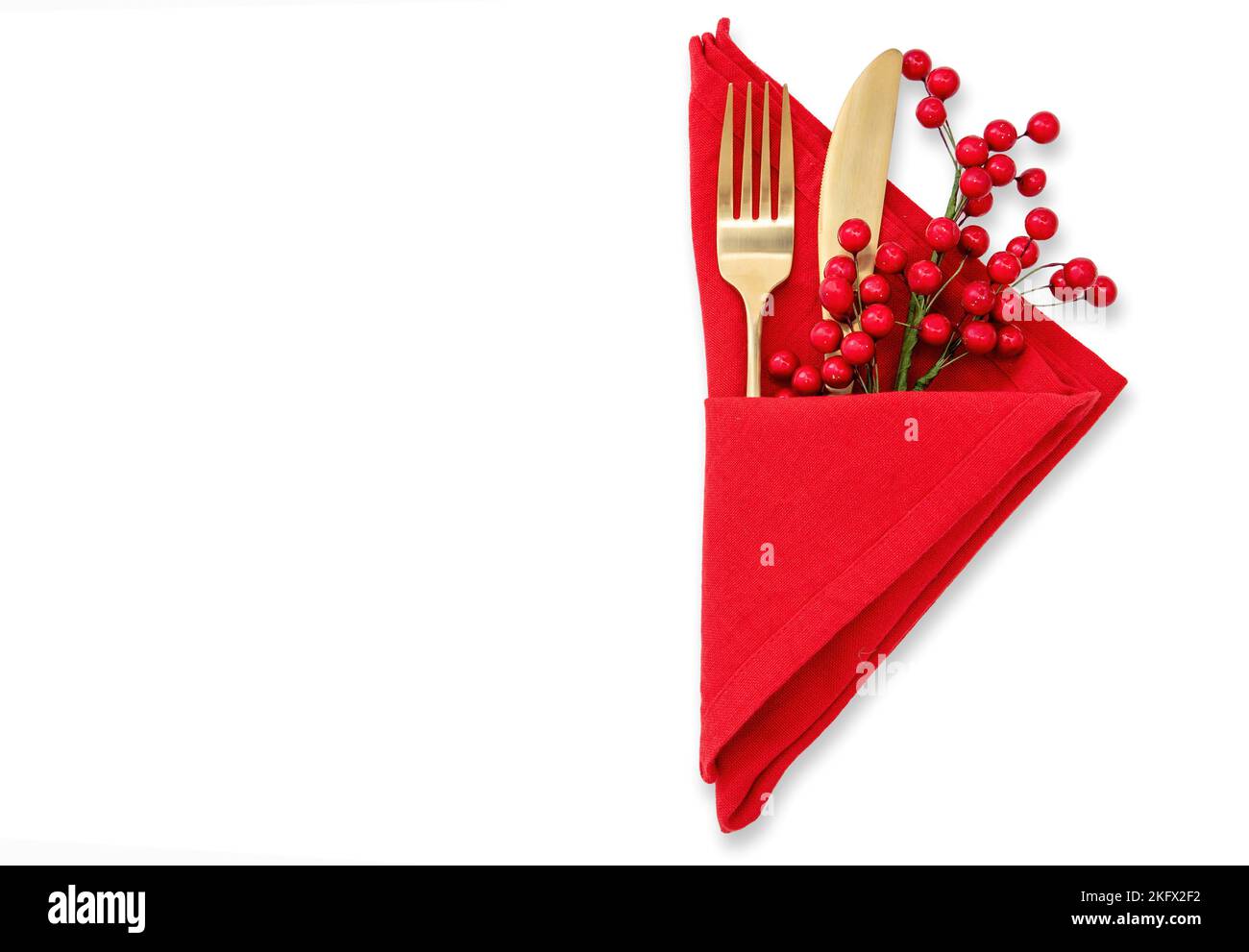 Holiday table setting. Golden Cutlery and red cloth napkin isolated on