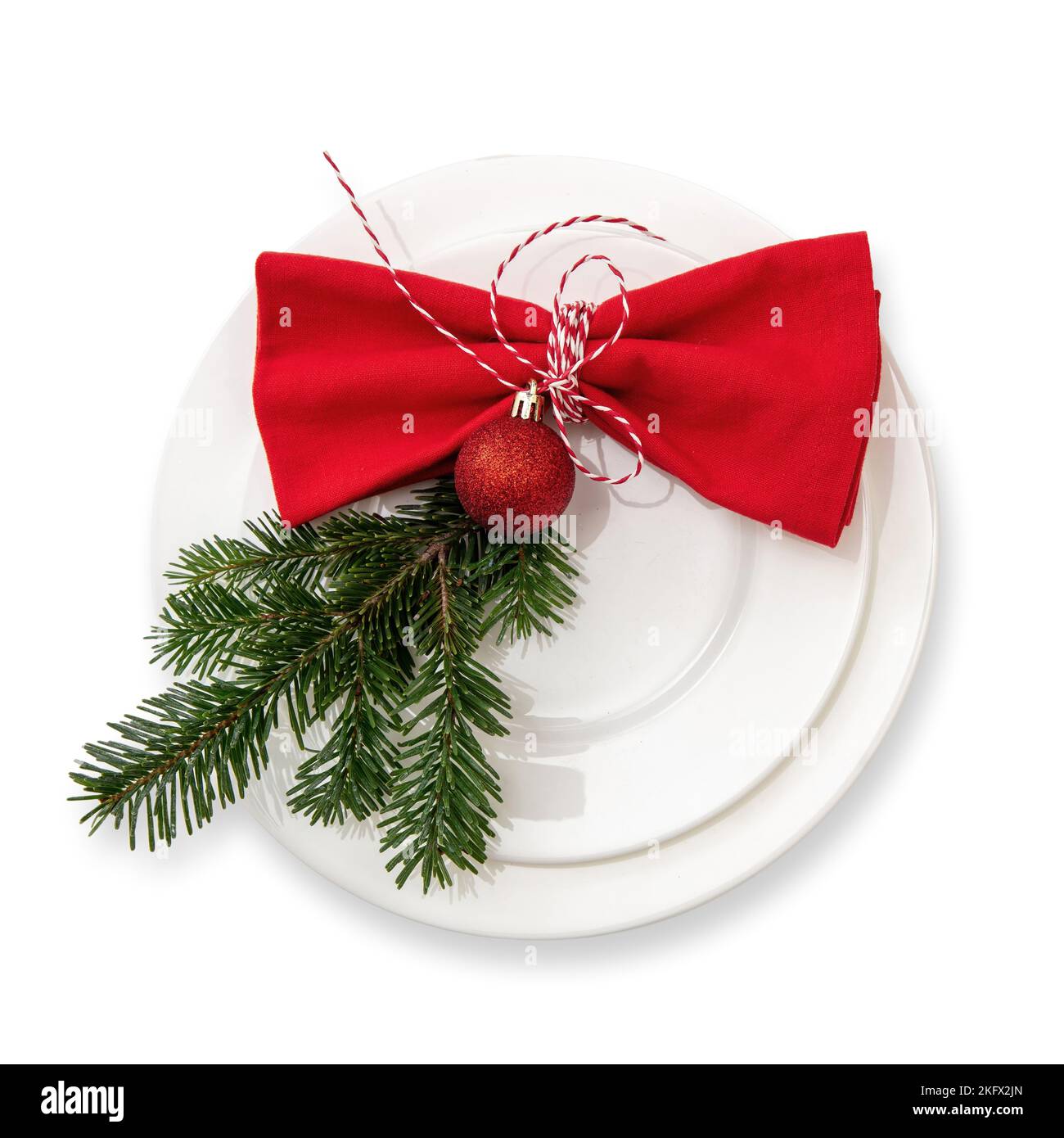 Christmas table setting, celebration dinner. Red cloth napkin and Xmas decoration on plates set, white background, top view Stock Photo