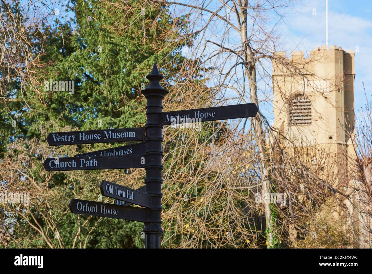 Signpost and the 15th century church tower of St Mary, Walthamstow Village, North East London, UK Stock Photo