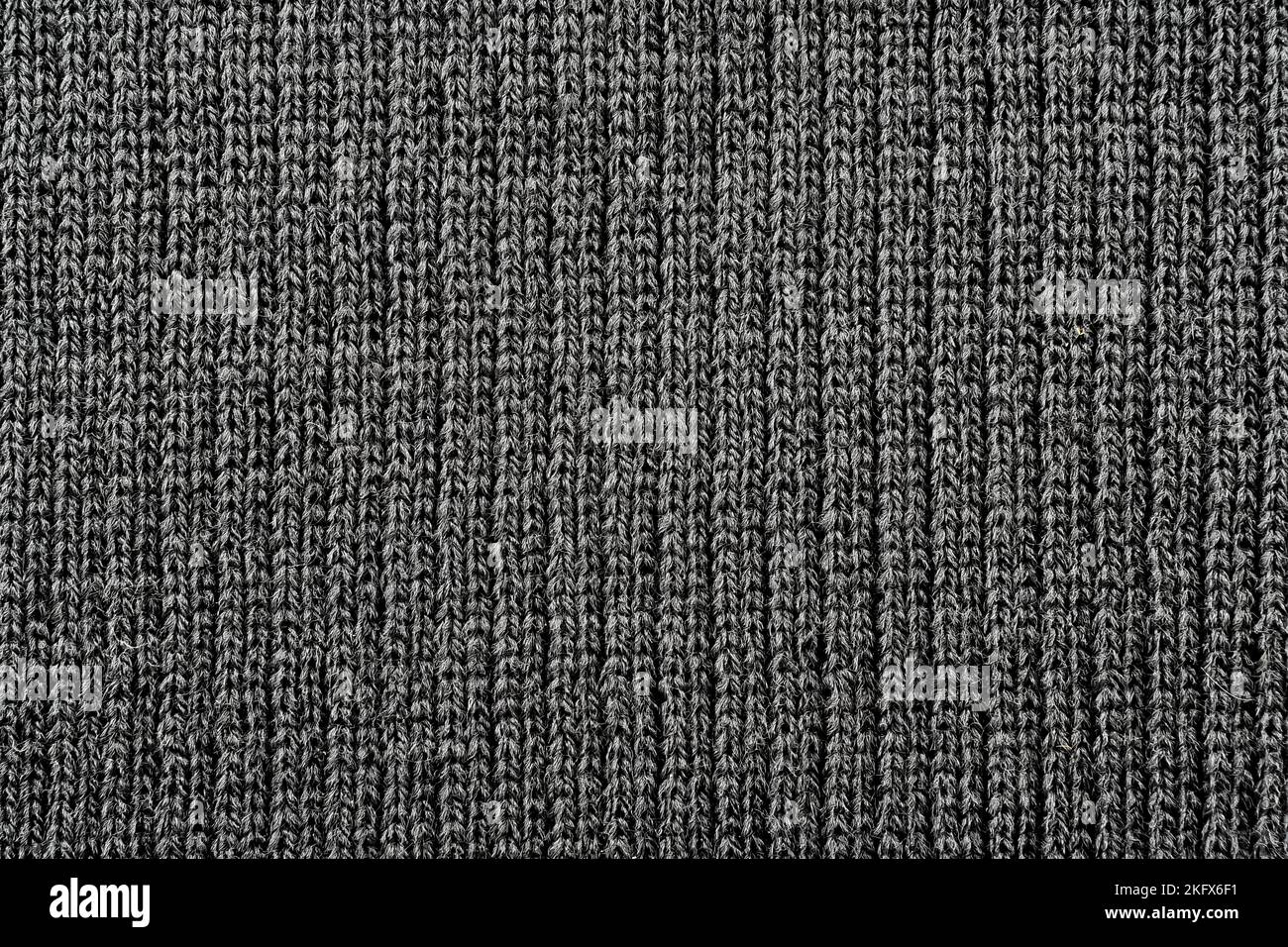 Texture of knitted fabric in dark color. Knitted material background Stock Photo