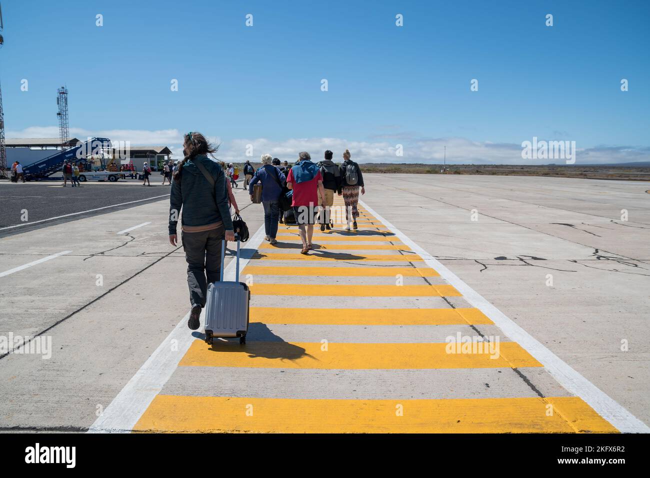 Passengers on the runway, disembarking from the plane, Seymour Airport, Galapagos Islands Stock Photo