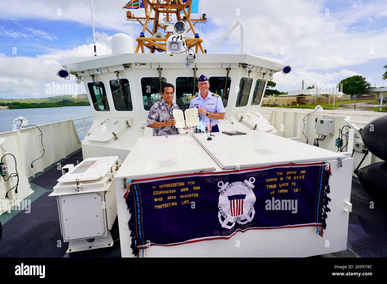 U.S. Coast Guard Forces Micronesia Sector Guam Commander Capt. Nicholas R. Simmons and the Honorable Joses R. Gallen, Secretary of Justice, Federated States of Micronesia, signed an expanded shiprider agreement allowing remote coordination of authorities, the first of its kind aboard the USCGC Myrtle Hazard (WPC 1139) in Guam, on Oct. 13, 2022. The agreement will enable to U.S to act on behalf of the FSM to combat illicit maritime activity and to strengthen international security operations. The weaving displayed is called a Thur, a cultural textile never worn as an everyday item of dress but Stock Photo