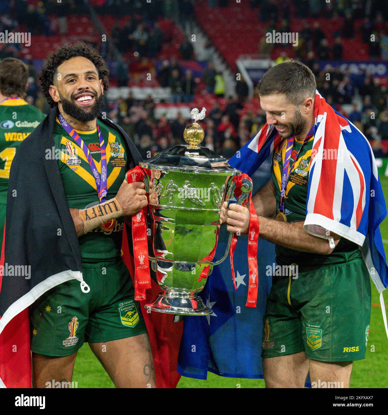 Manchester, UK. 18th Nov, 2022. Josh Addo-Carr (Canterbury Bankstown Bulldogs) of Australia (9) and James Tedesco (C) (Sydney Roosters) of Australia (1) with the trophy after winning the 2021 Rugby League World Cup Final 2021 match between Australia and Samoa at Old Trafford, Manchester, England on 19 November 2022. Photo by David Horn. Credit: PRiME Media Images/Alamy Live News Stock Photo