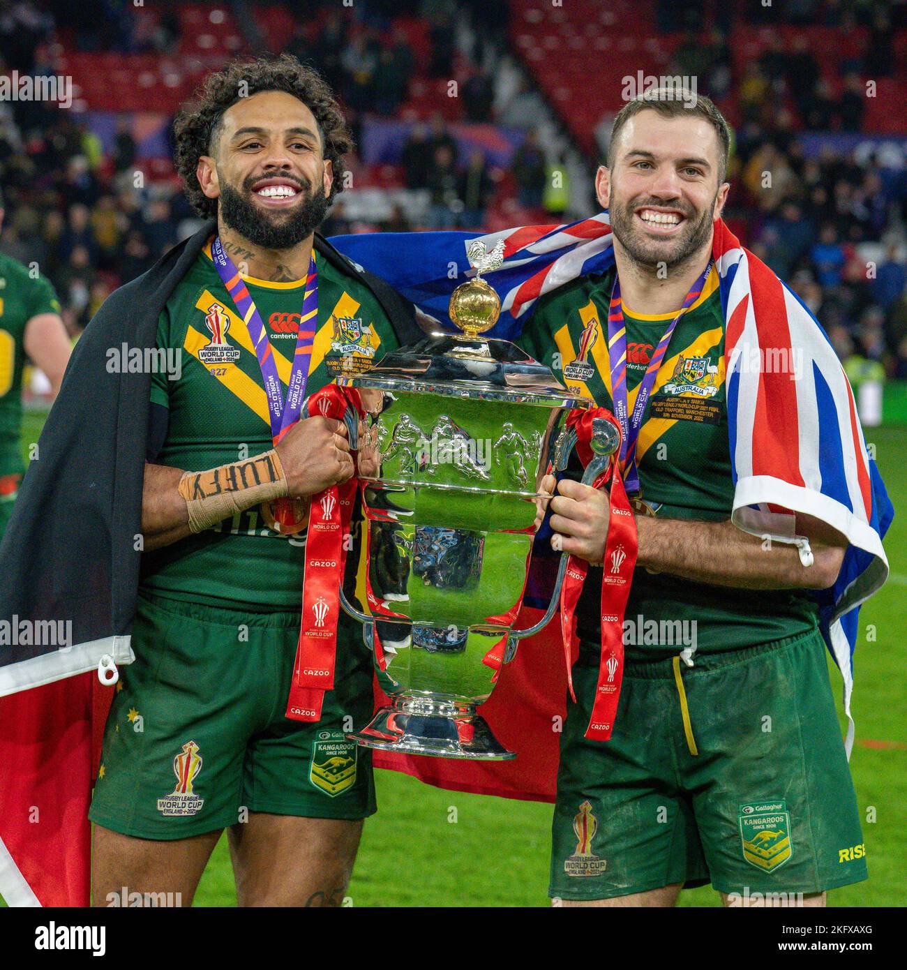 Manchester, UK. 18th Nov, 2022. Josh Addo-Carr (Canterbury Bankstown Bulldogs) of Australia (9) and James Tedesco (C) (Sydney Roosters) of Australia (1) with the trophy after winning the 2021 Rugby League World Cup Final 2021 match between Australia and Samoa at Old Trafford, Manchester, England on 19 November 2022. Photo by David Horn. Credit: PRiME Media Images/Alamy Live News Stock Photo