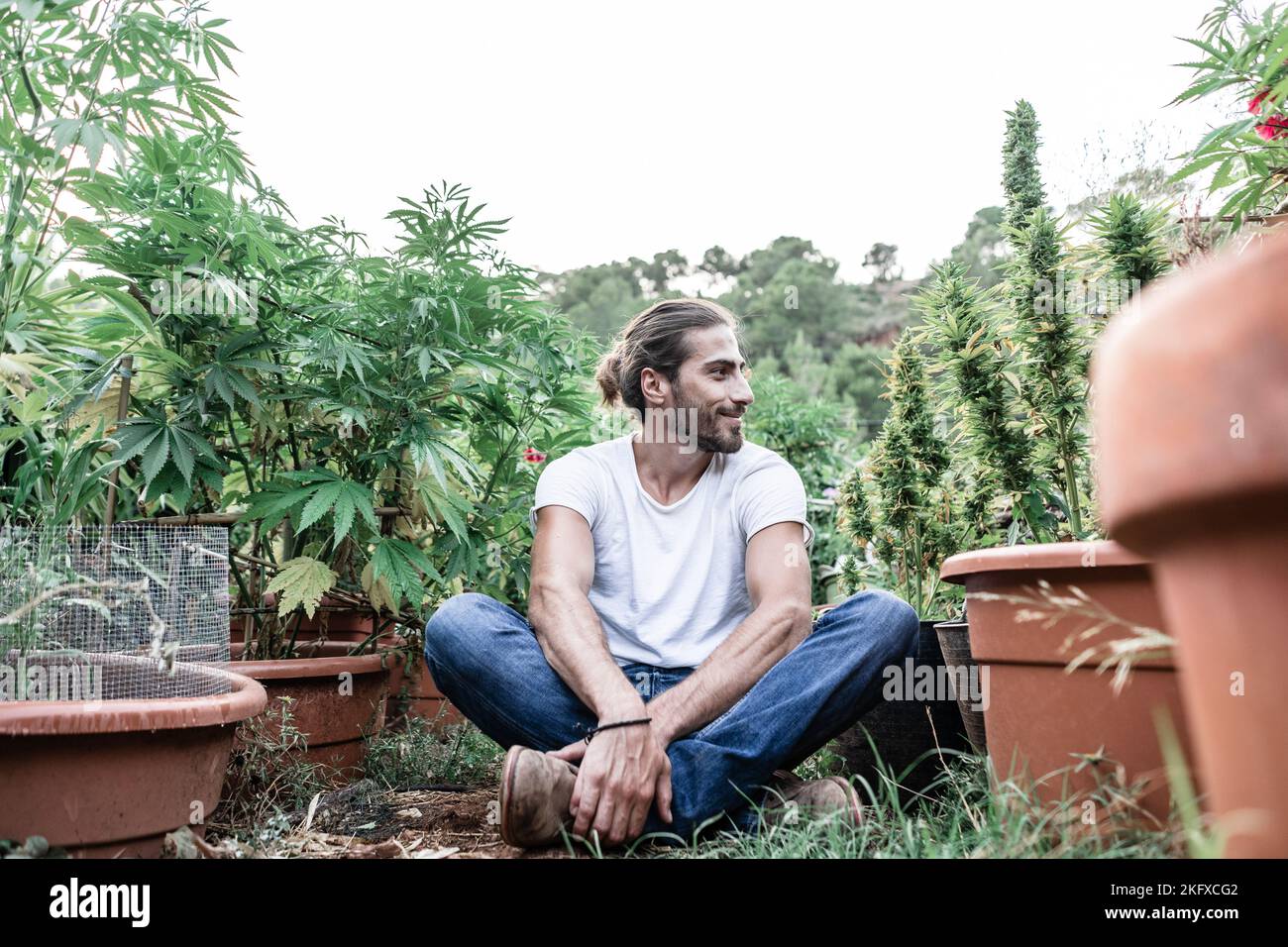 smiling caucasian guy sitting on the floor with his legs crossed