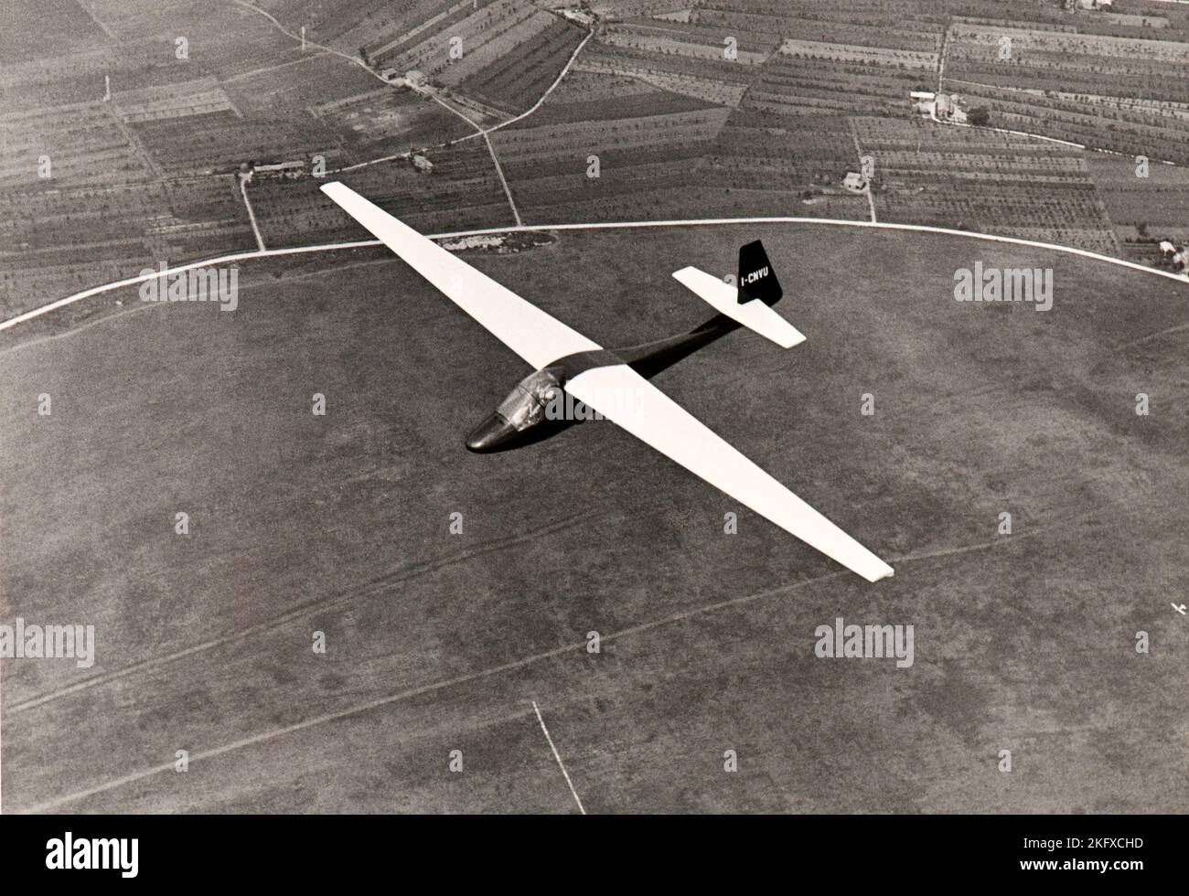 A glider soars over the countryside of Piedmont (Italy) in mid fifties Stock Photo