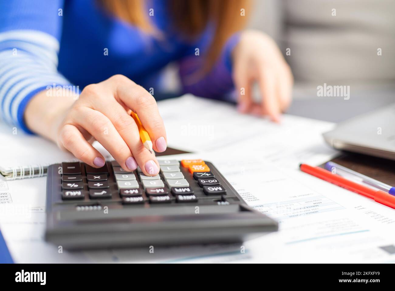 Close up young woman using calculator, managing household monthly budget Stock Photo