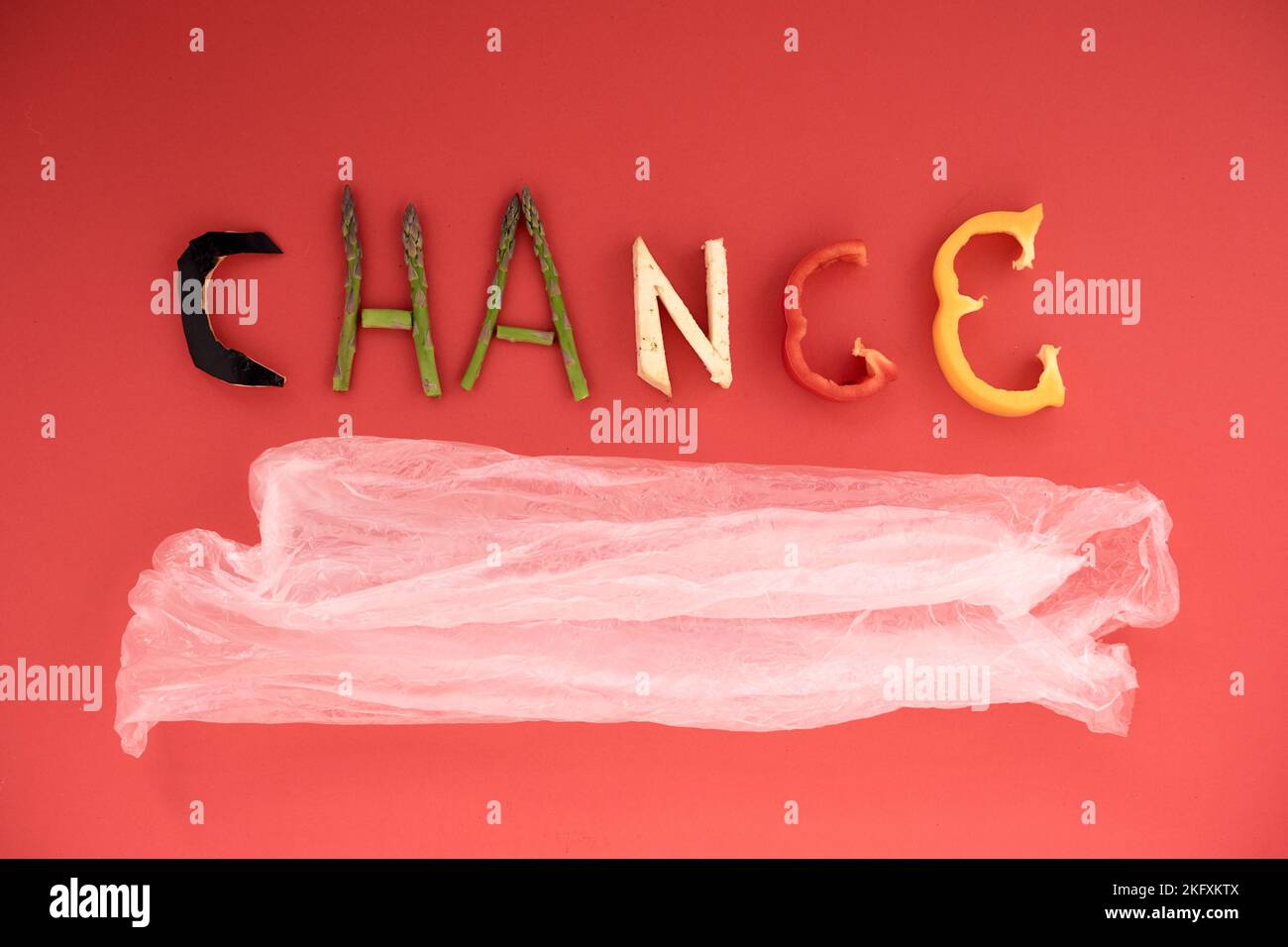 formation of the word change with pieces of vegetables to raise awareness about climate change and the use of plastic on a red background Stock Photo