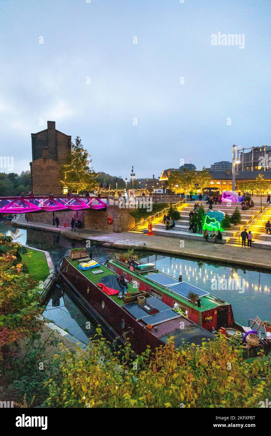 Espérance Bridge and Canalside Green Steps by the Regents Canal illuminated at night in Kings Cross, Camden, London, UK Stock Photo