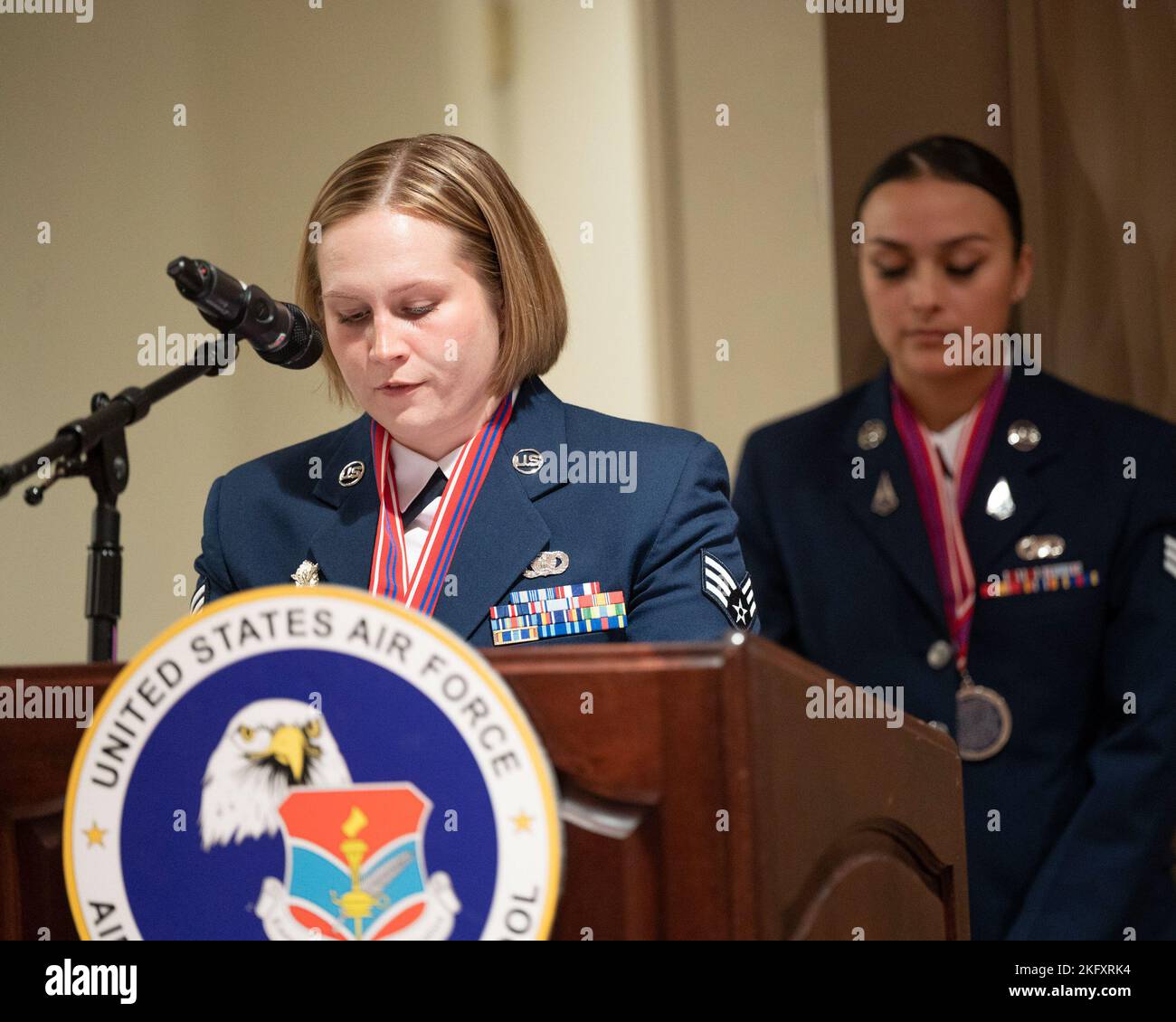 U.S. Air Force Senior Airman Nicolette Folck gives the benediction while U.S. Space Force Specialist 4 Monica Cisineros bows her head at the conclusion of  Grace A. Peterson Airman Leadership School class 22-G Oct. 13, 2022, at Wright-Patterson Air Force Base, Ohio. ALS is required for senior airmen selected for staff sergeant to teach them about leadership and Air Force culture and is open to eligible civilians. Stock Photo