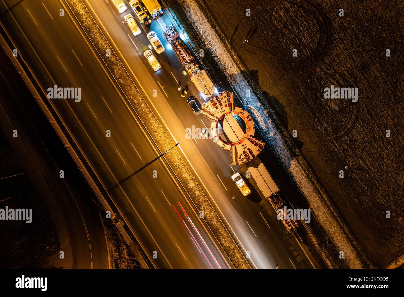 Convoy transporting heavy equipment, aerial night landscape of TBM machine Stock Photo