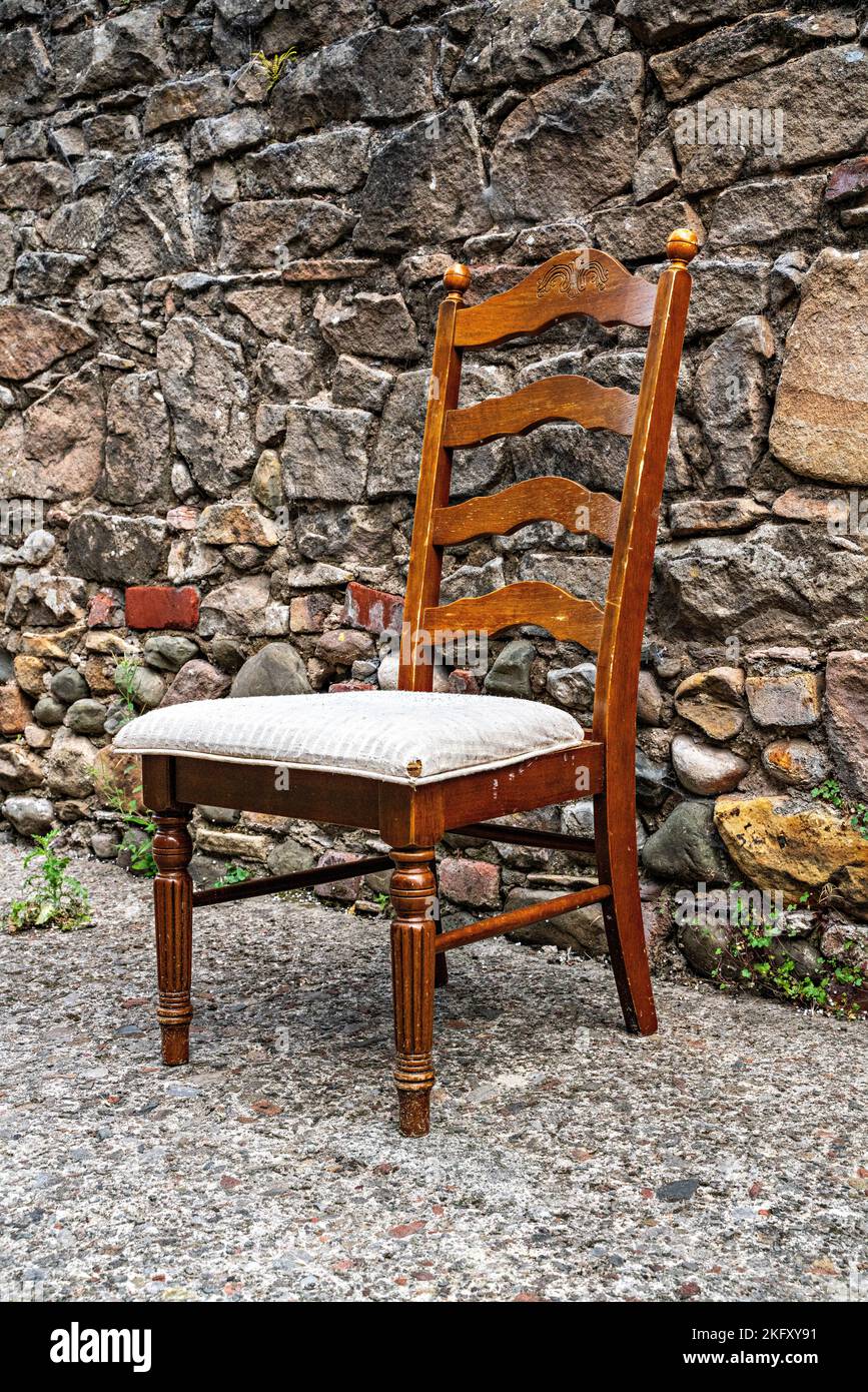 Wooden dining chair left in street Stock Photo