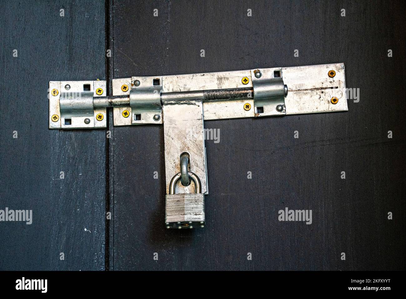 Padlock securing steel bolt on gates Stock Photo Alamy