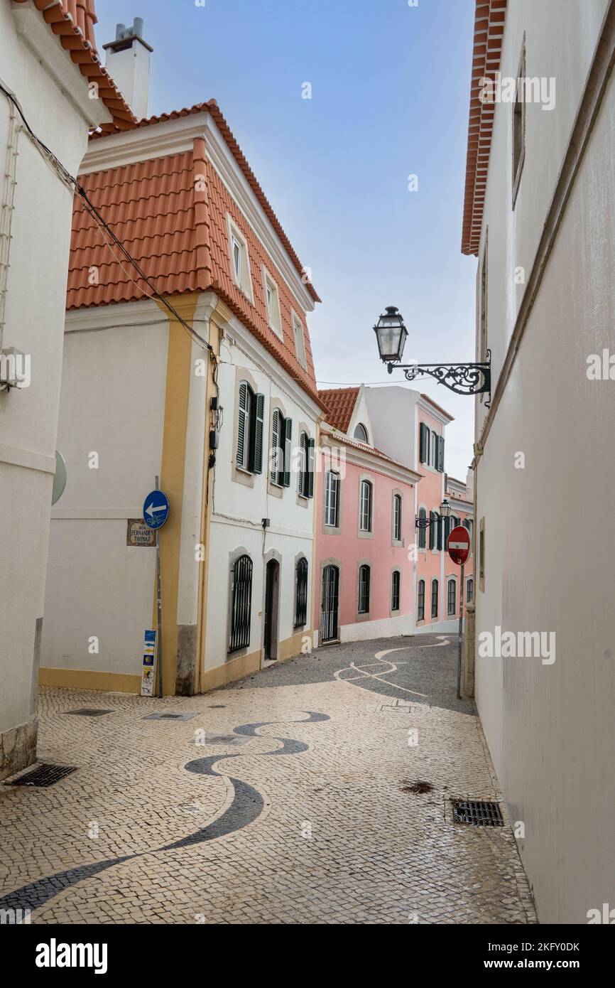 Cascais, Portugal - September 2022: Mediterranean house with green louvered window and shutters. traditional town street with vintage buildings Stock Photo