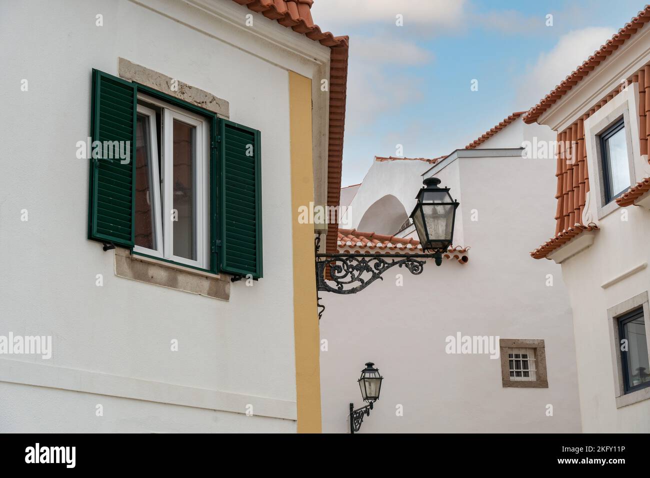 Mediterranean house with green louvered window and shutters. traditional town street with vintage buildings Stock Photo