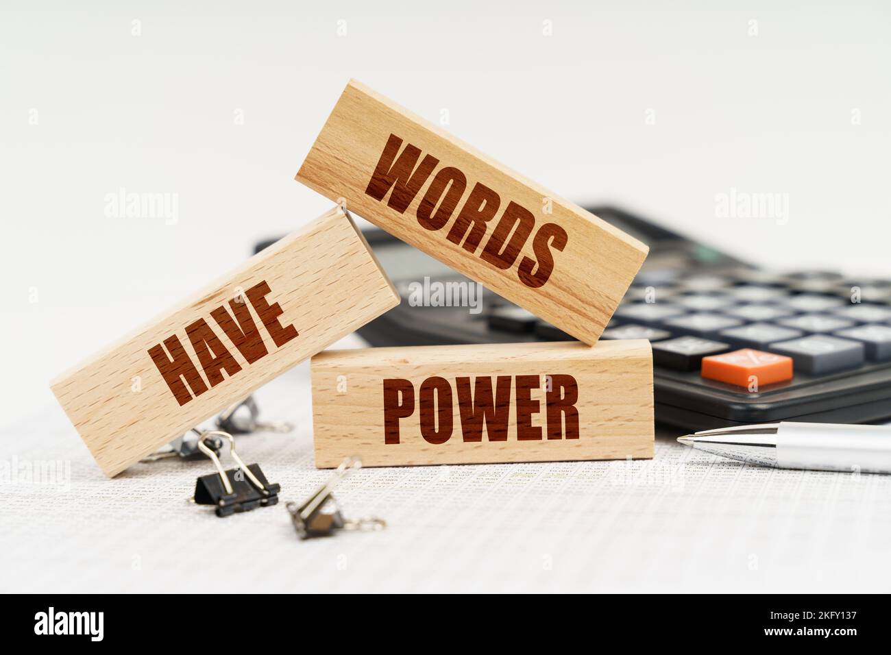 Business and Economics. On the table is a pen, a calculator and small wooden blocks with the inscription - Words Have Power Stock Photo