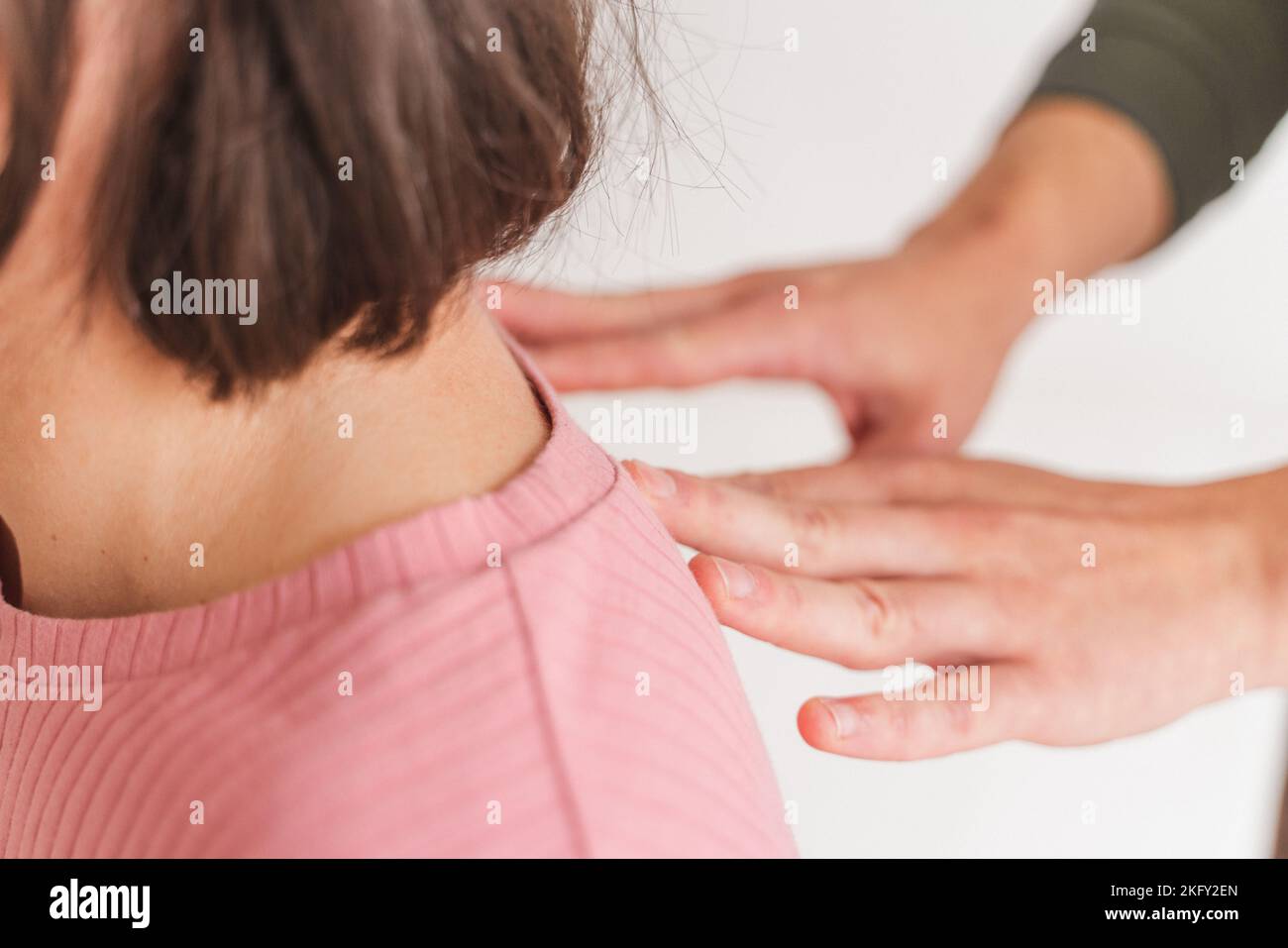 A close-up shot of female hands giving shoulder massage to a pregnant woman - Hypnobirthing concept Stock Photo