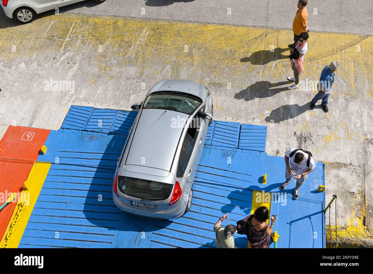 Piraeus, Athens, Greece - June 2022: Aerial view of a vehicle driving off the front of a car ferry with passengers disembarking on foot Stock Photo