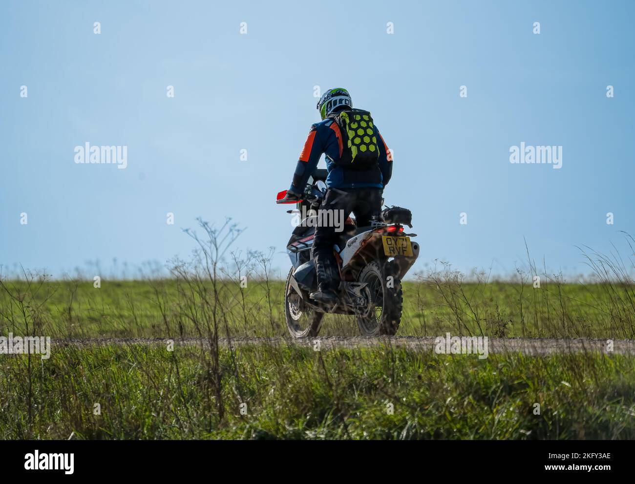 motor cyclist (biker) riding an offroad motorbike along a stone track