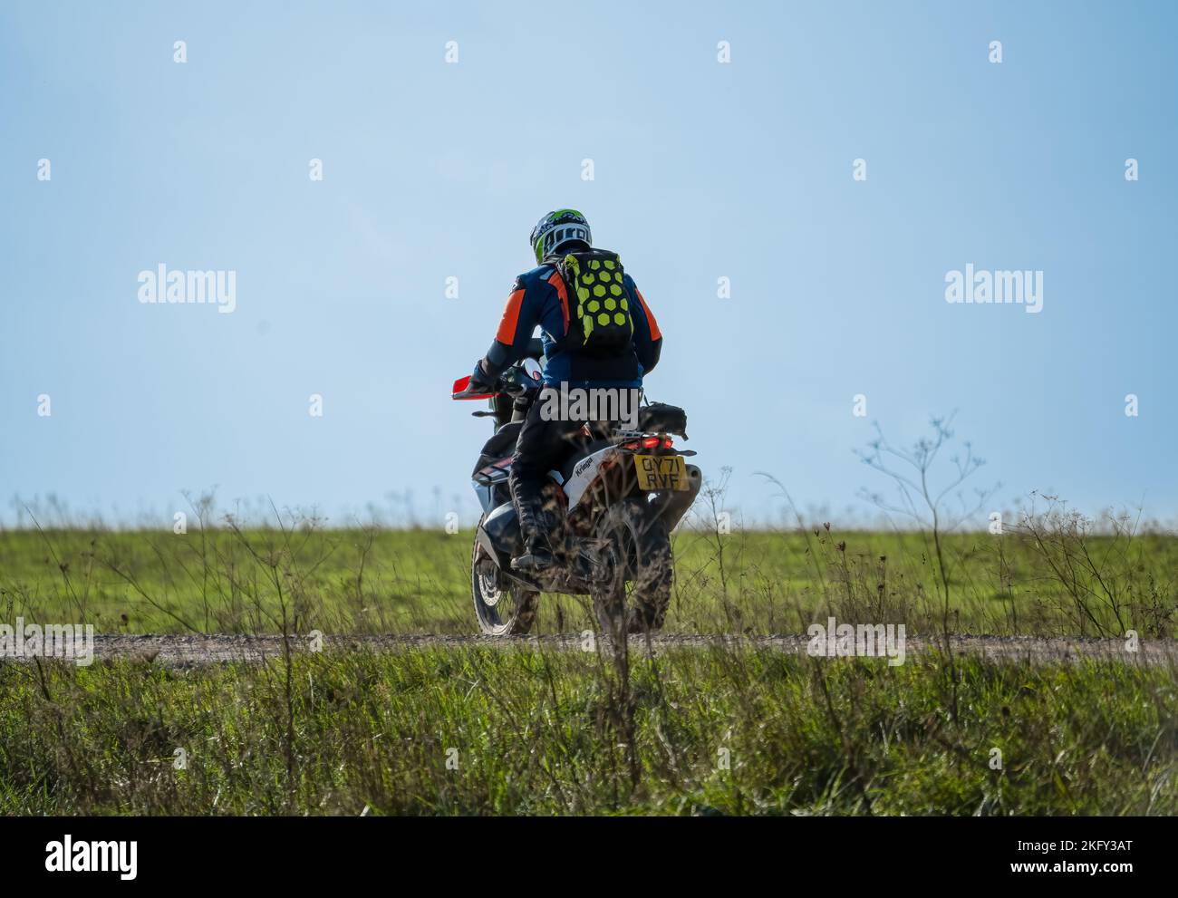 motor cyclist (biker) riding an offroad motorbike along a stone track