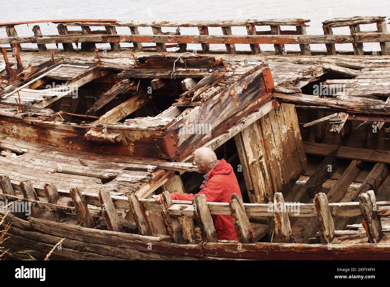 An large, old, wrecked wooden boat, in dry dock, showing the rotting