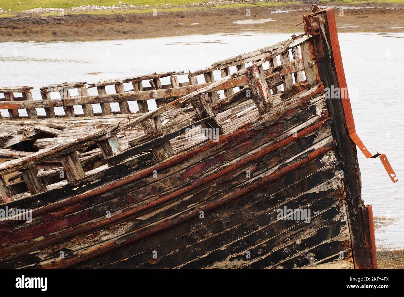 An large, old, wrecked wooden boat, in dry dock, showing the rotting timbers, nuts and bolts and metal as it is slowly disintigrating Stock Photo