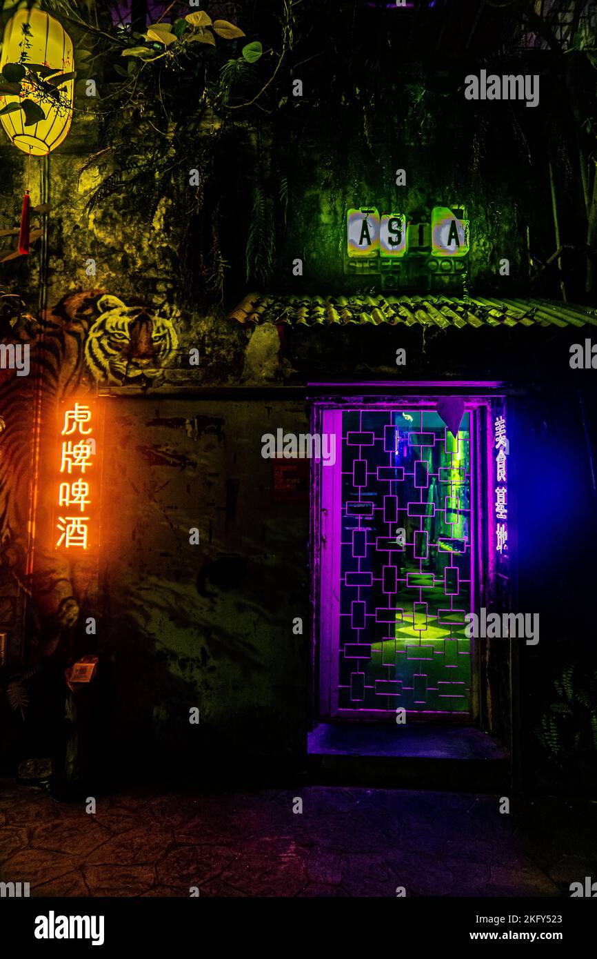 A vertical shot of the buildings with neon lights at night. Kuala