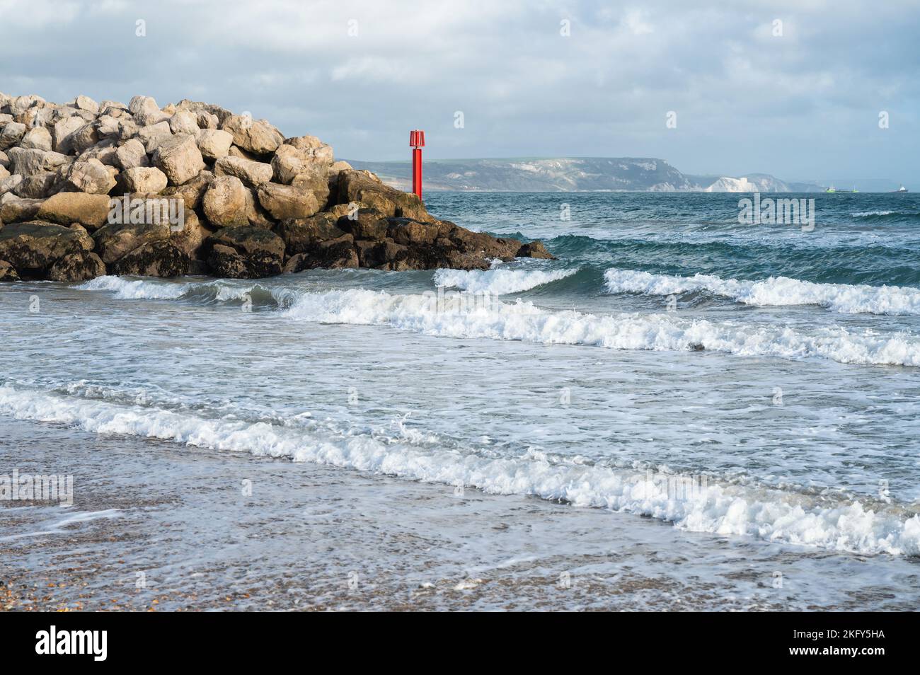 Seaside town of Weymouth in Dorset, United Kingdom. View of the waves in the sea, rocks in the background, selective focus Stock Photo