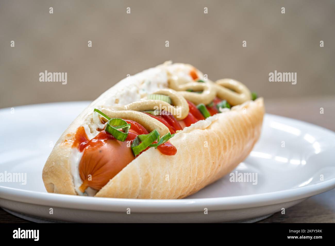 hot dog with mustard ketchup and spring onion Stock Photo