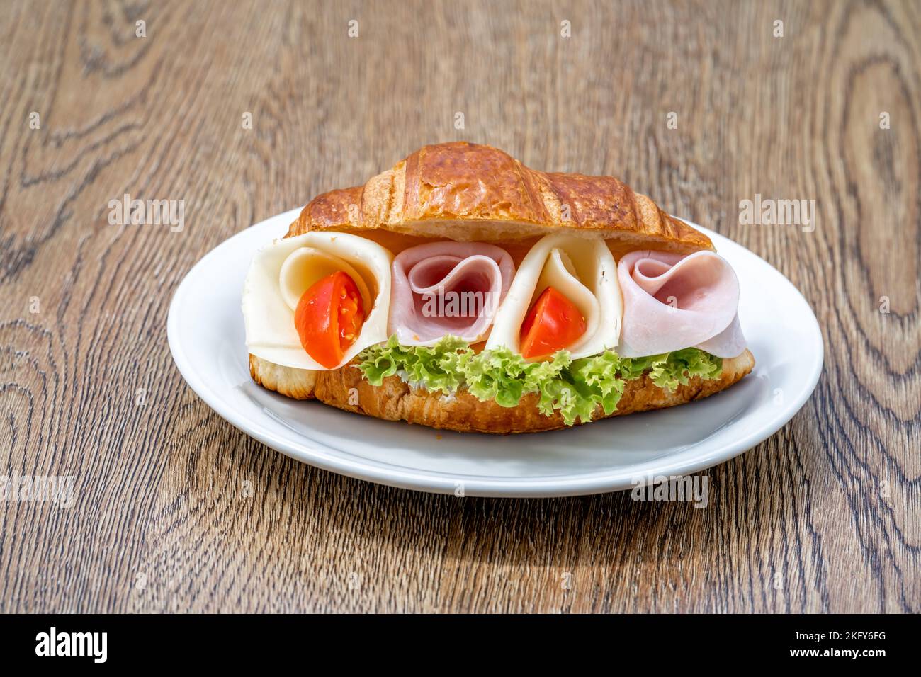 Croissant filled with ham, cheese and vegetables Stock Photo
