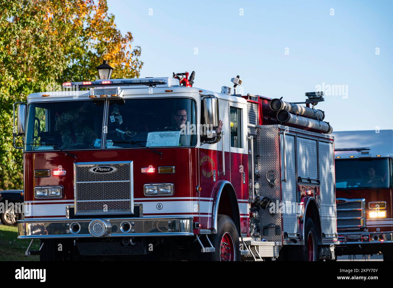 436th Civil Engineer Squadron Airmen wave to housing residents from an