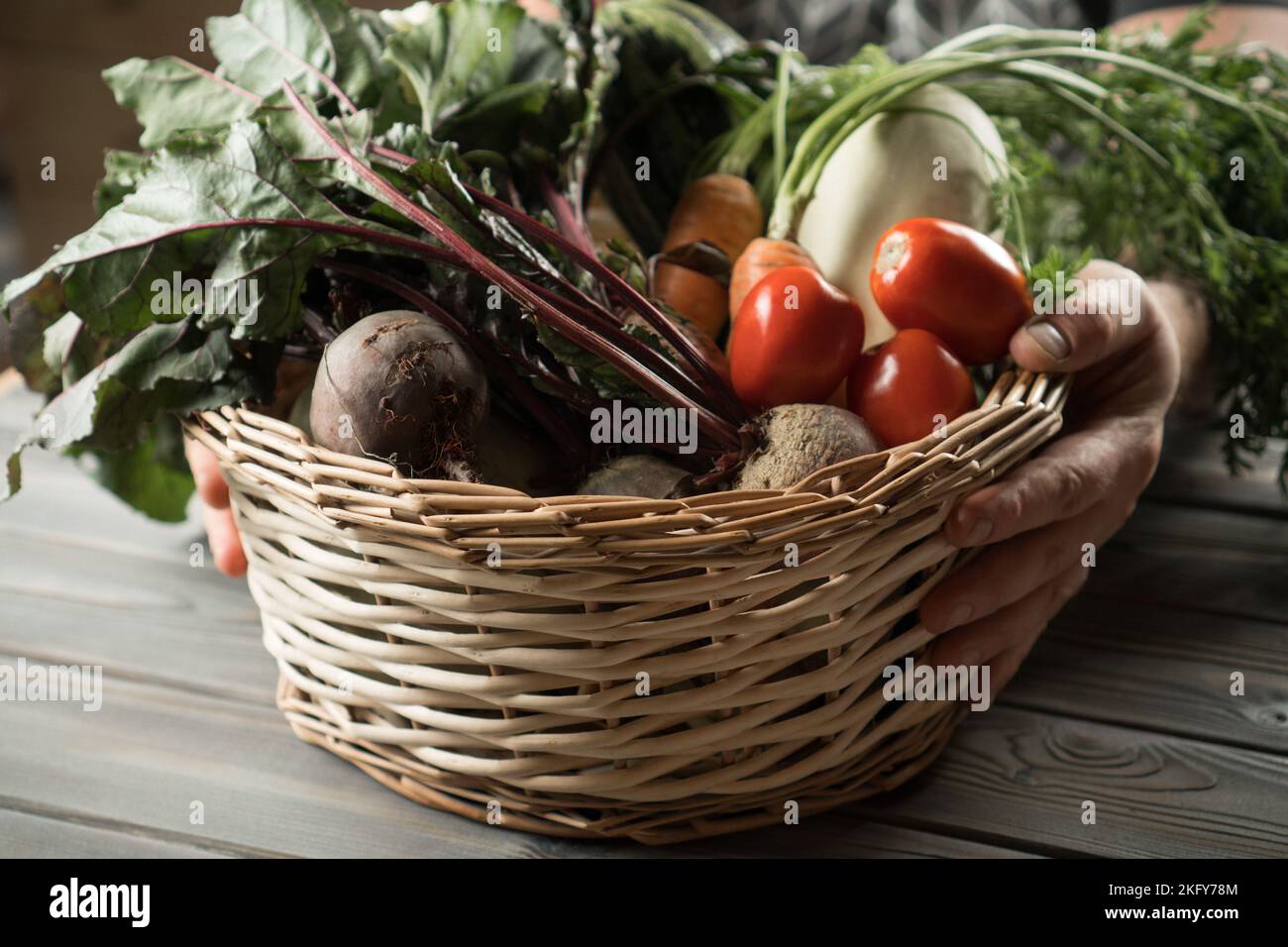 Unrecognizable man hands holding wicker basket with fresh vegetable ...