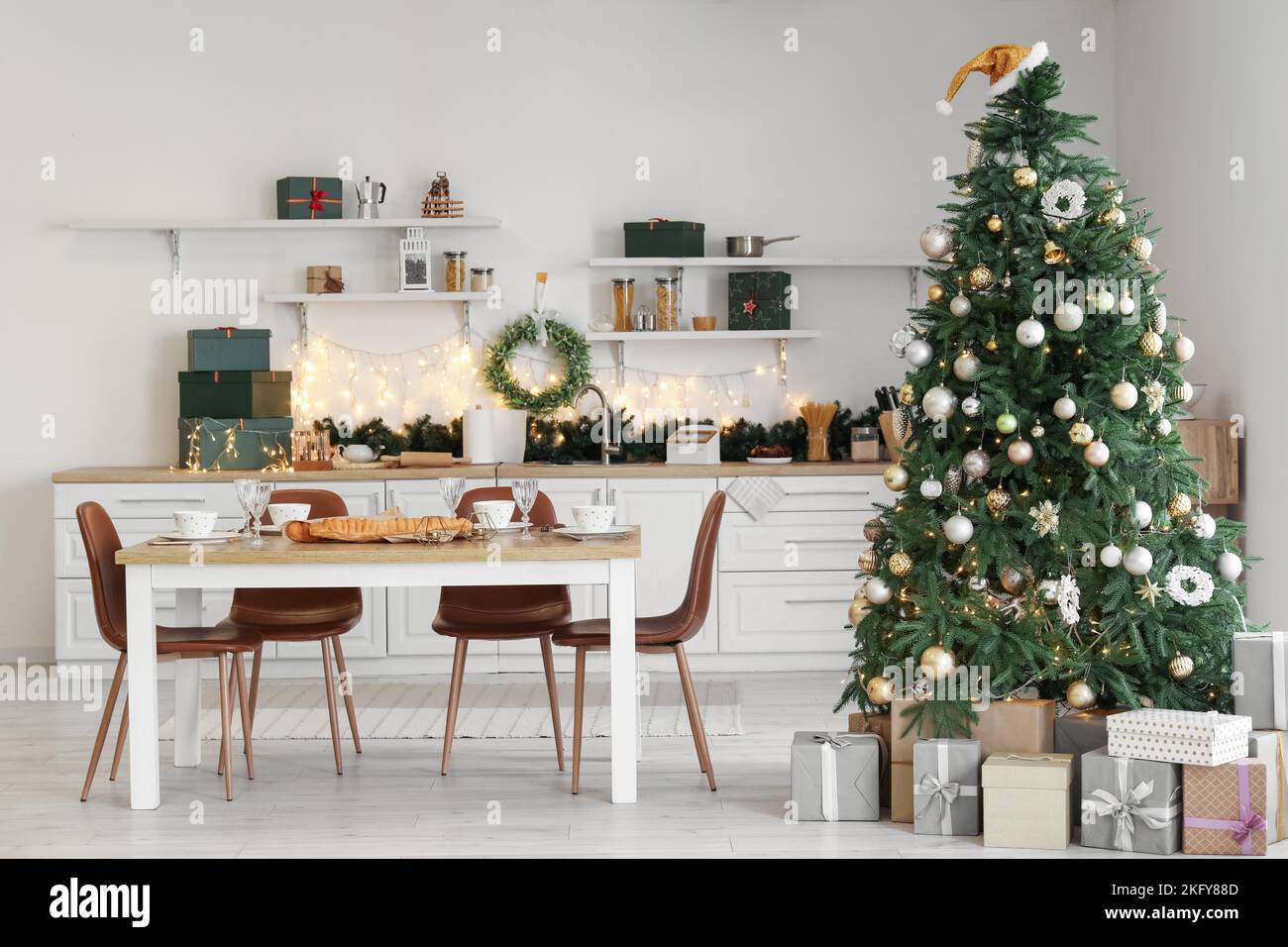 Interior of kitchen with Christmas tree and dining table Stock Photo ...