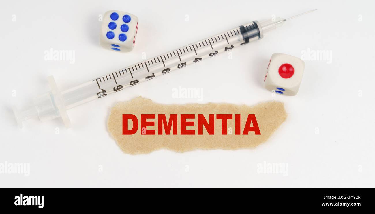 Medical concept. On a white surface lies a syringe, dice and a piece of