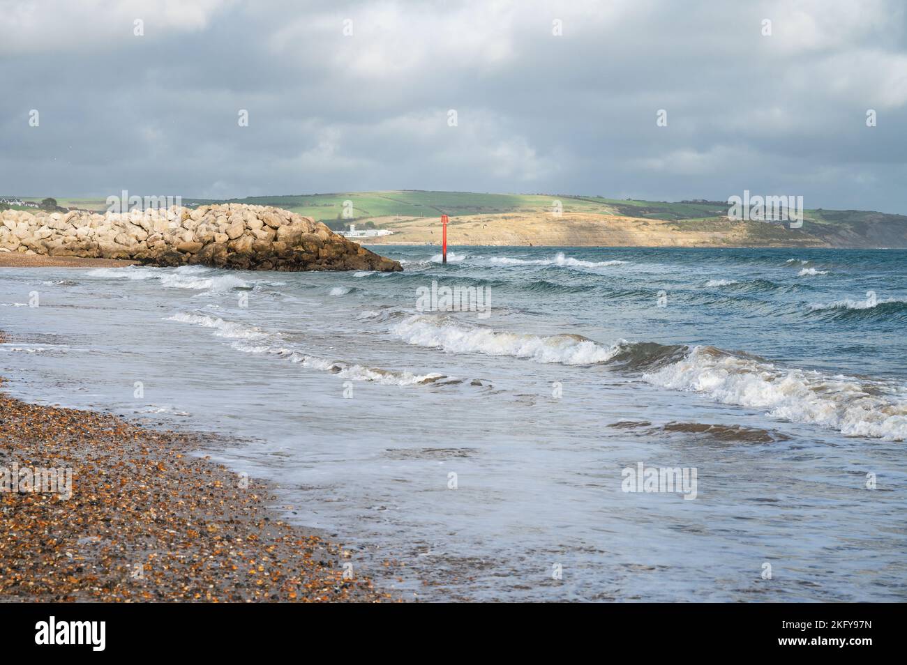 Seaside town of Weymouth in Dorset, United Kingdom. View of the waves in the sea, rocks in the background, selective focus Stock Photo
