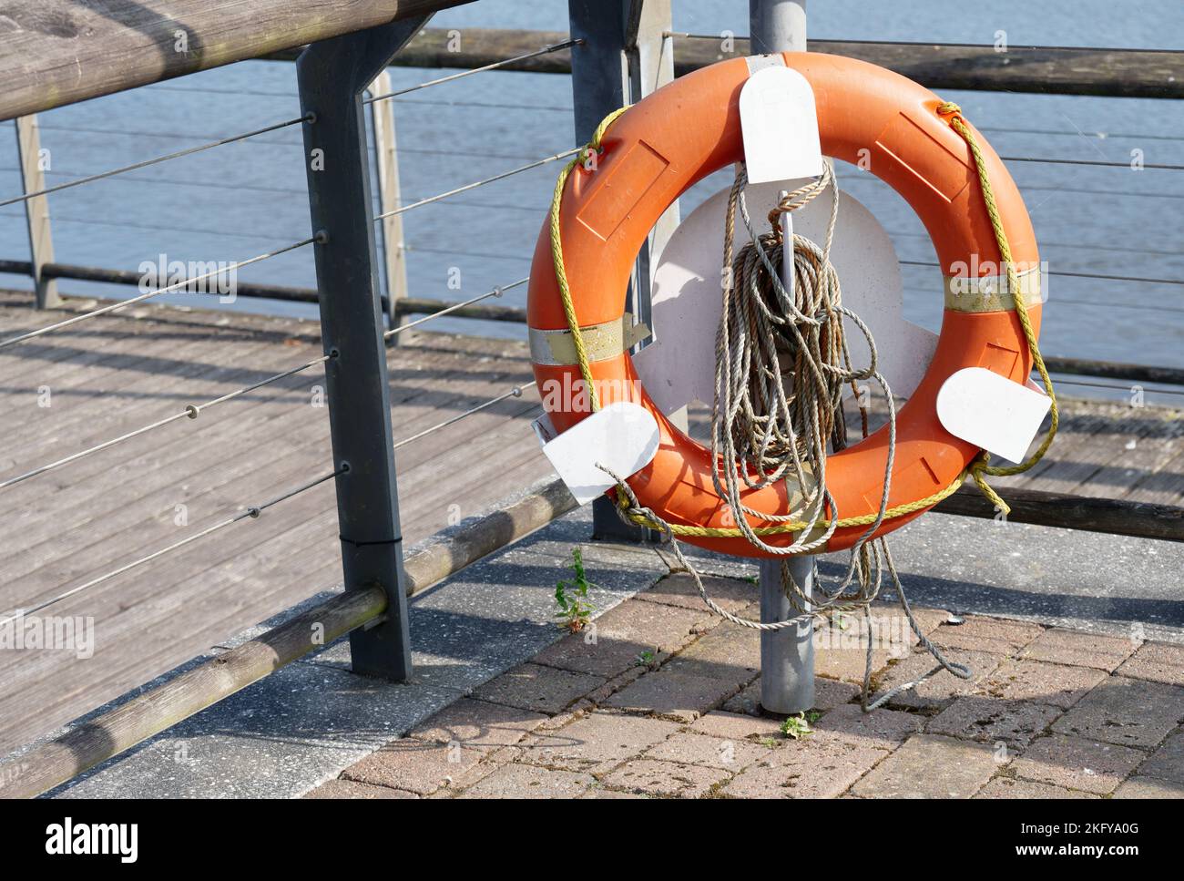 Red buoy life safety ring on post at riverbank Stock Photo Alamy