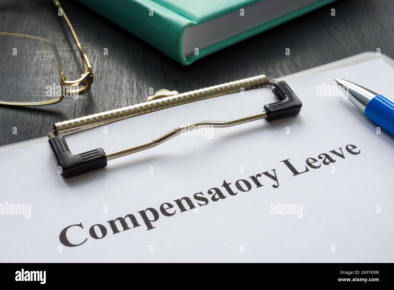 Document about Compensatory leave and pen for signing. Stock Photo