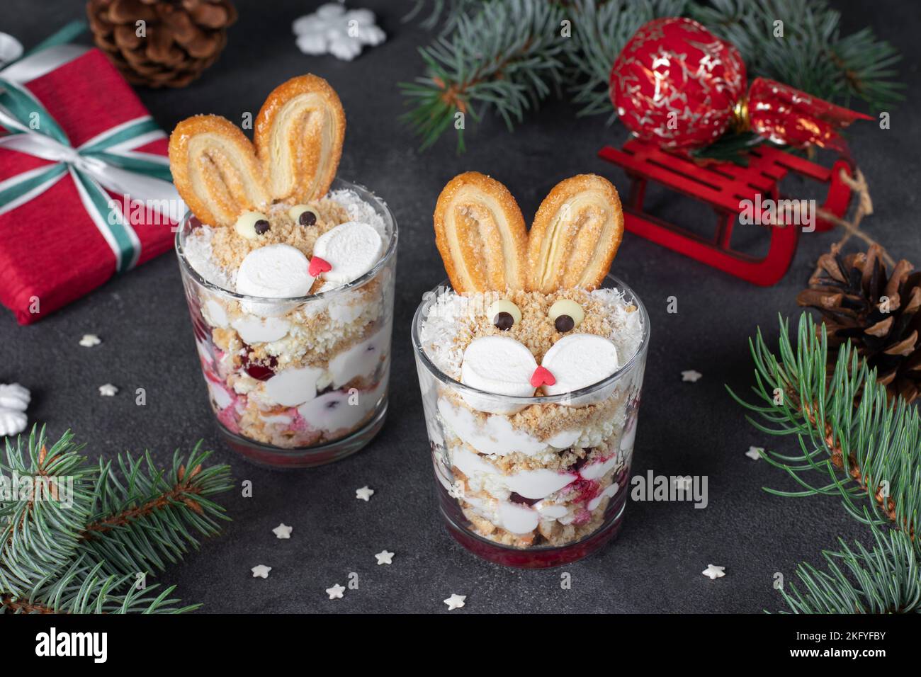 New Year's dessert in glasses the form of cute rabbits with cherries, cookies and curd cream on