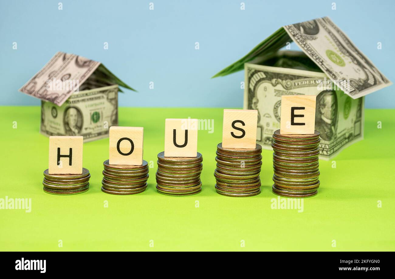 A row of American quarters with wooden block letters and money houses Stock Photo