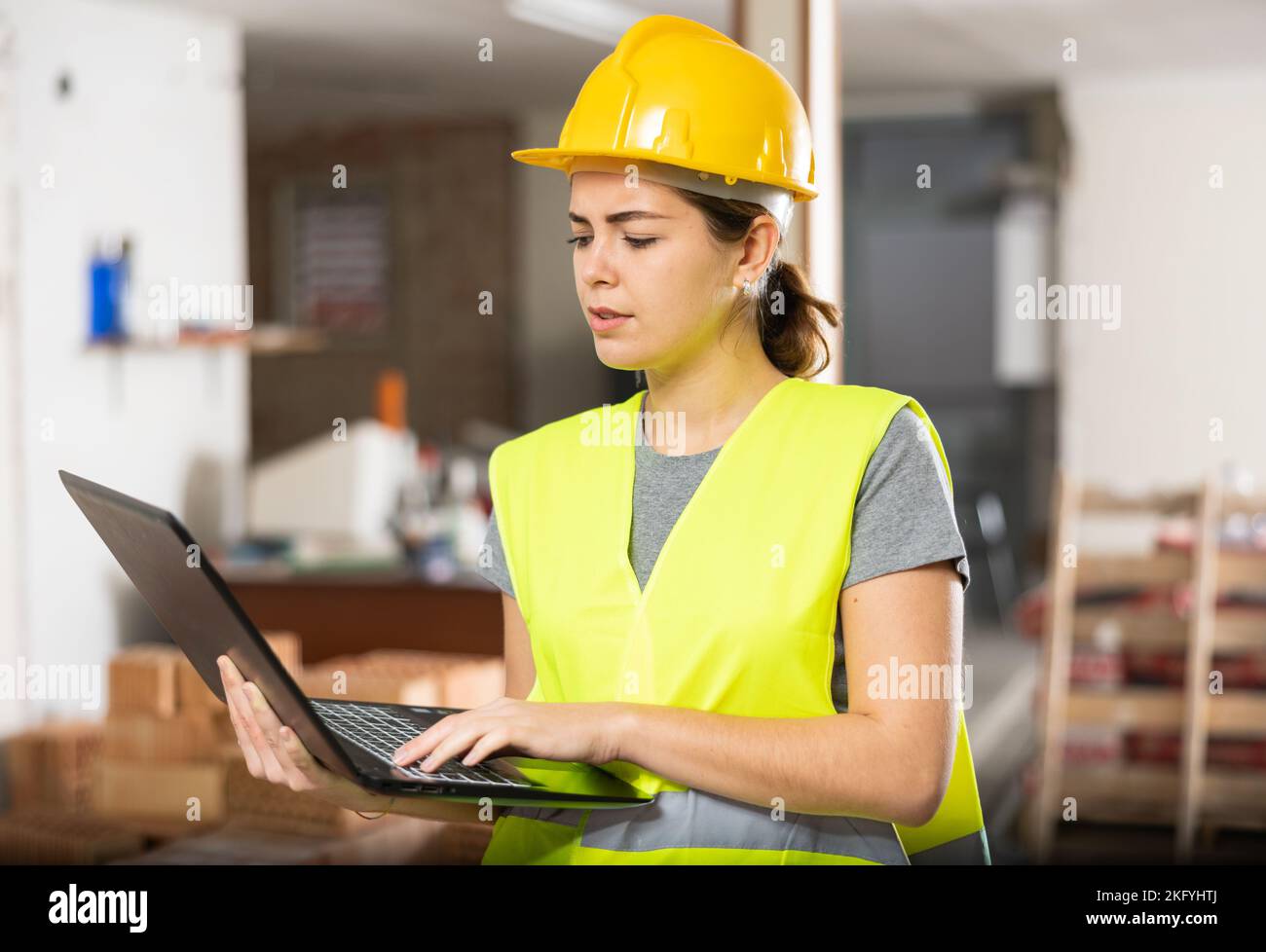 Female engineer using laptop in apartment Stock Photo