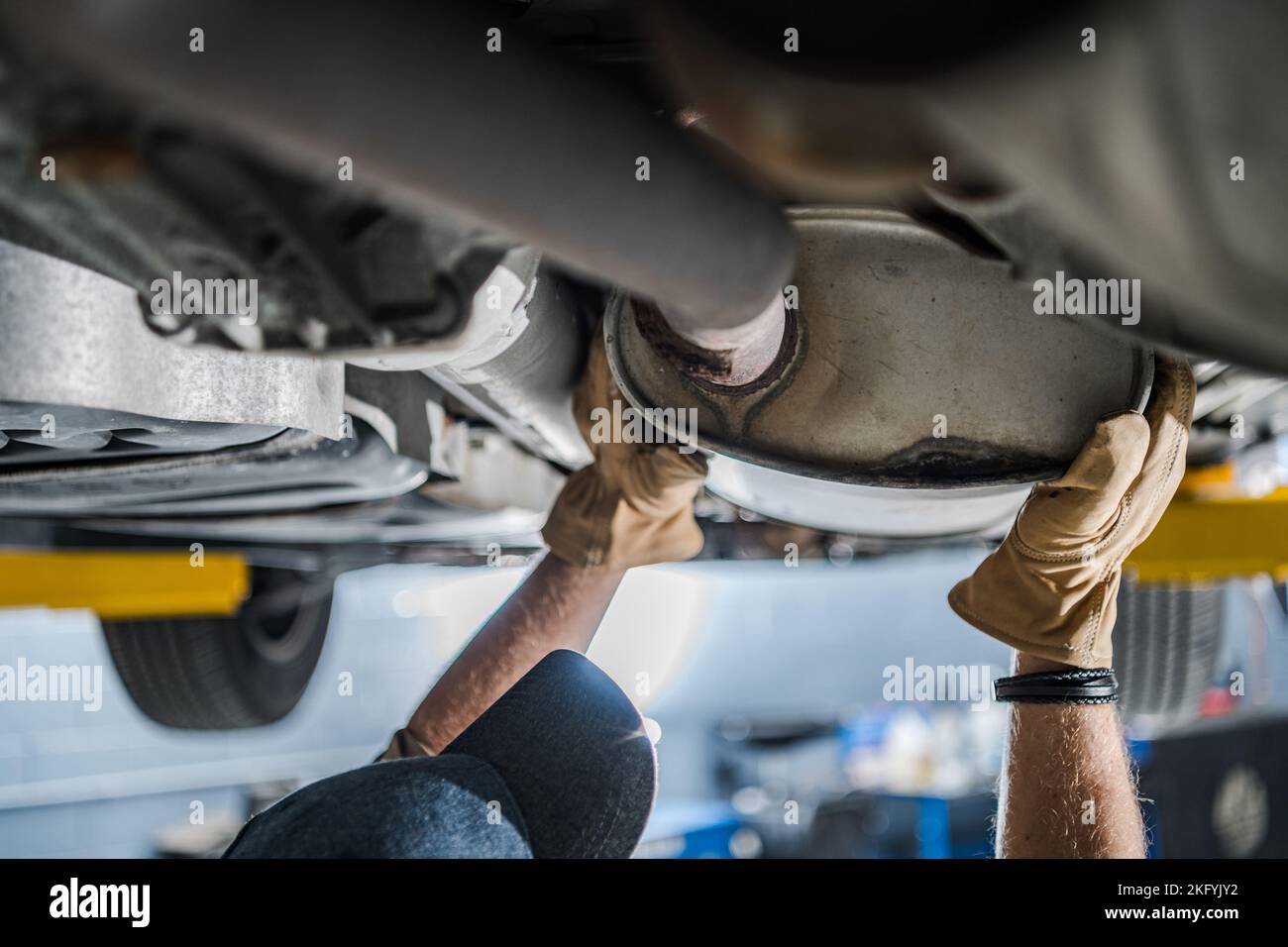 Mechanic Inspecting Vehicle's Catalytic Converter During Scheduled Car Exhaust System Check
